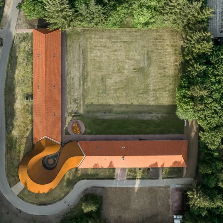 The view from above shows the round new building that connects the two historic buildings with the tiled roofs (© R_Hjortshoj) The view from above shows the round new building that connects the two historic buildings with the tiled roofs (© R_Hjortshoj)
